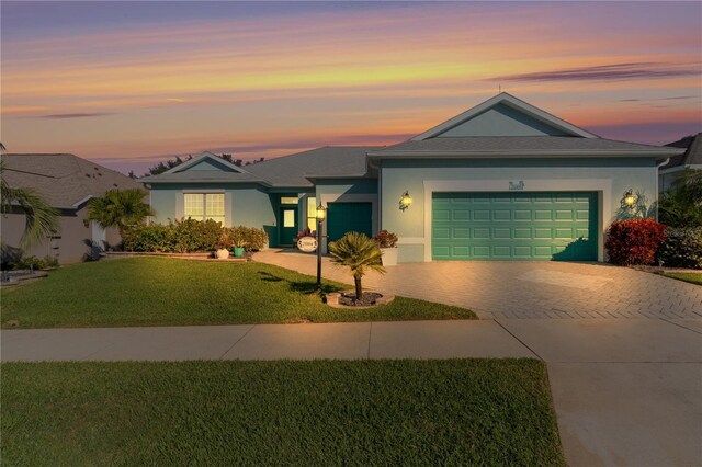 25304 Forest Oak Ct, Leesburg, FL 34748 - view of front facade featuring an attached garage, a front lawn, driveway, and stucco siding
