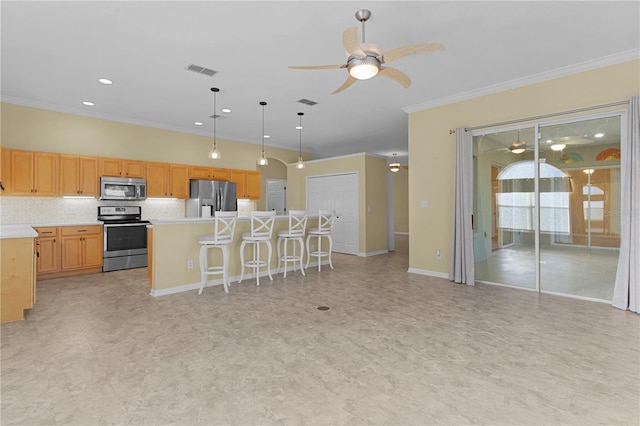 kitchen featuring backsplash, crown molding, a center island, and stainless steel appliances