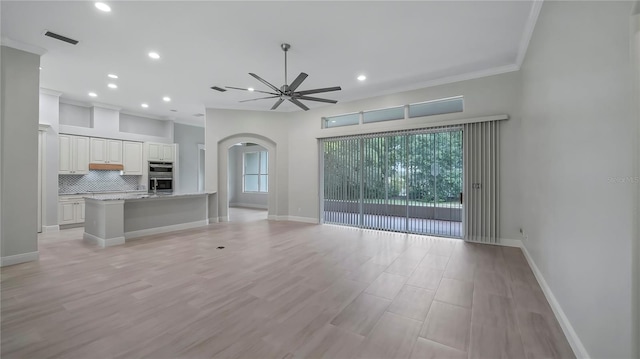 unfurnished living room featuring ceiling fan, light wood-type flooring, and crown molding