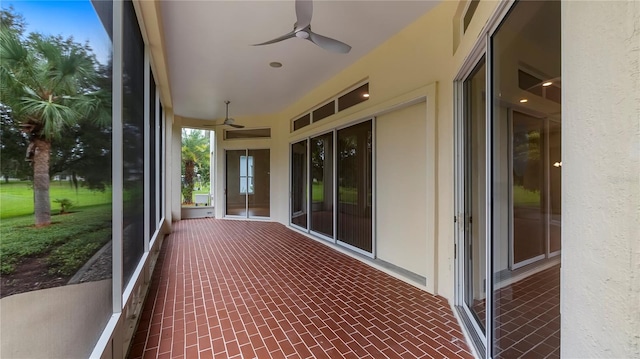 unfurnished sunroom with ceiling fan