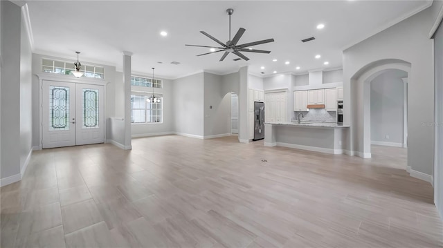 foyer entrance featuring crown molding, ceiling fan, french doors, and light hardwood / wood-style floors