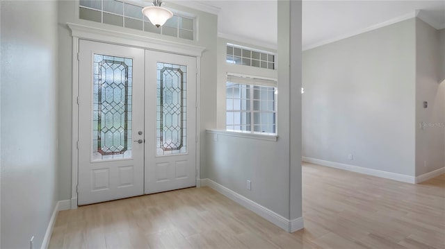 entryway with french doors, light wood-type flooring, and crown molding