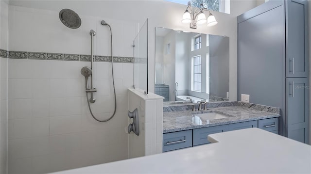 bathroom with a tile shower and vanity