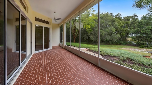 unfurnished sunroom featuring ceiling fan