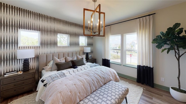 bedroom with a chandelier and light hardwood / wood-style floors