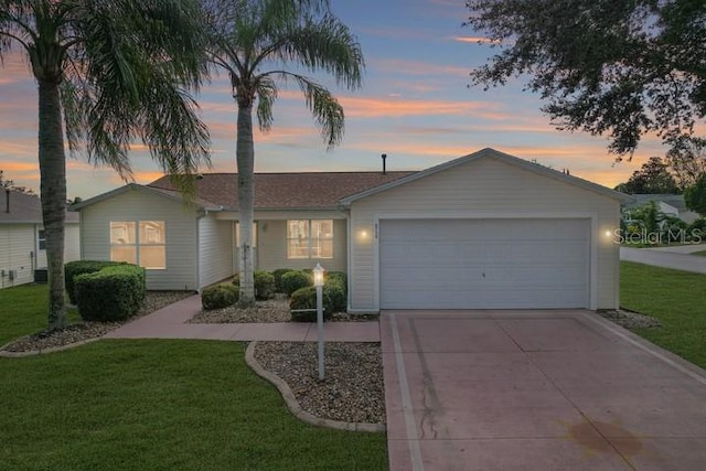 single story home featuring a garage and a yard