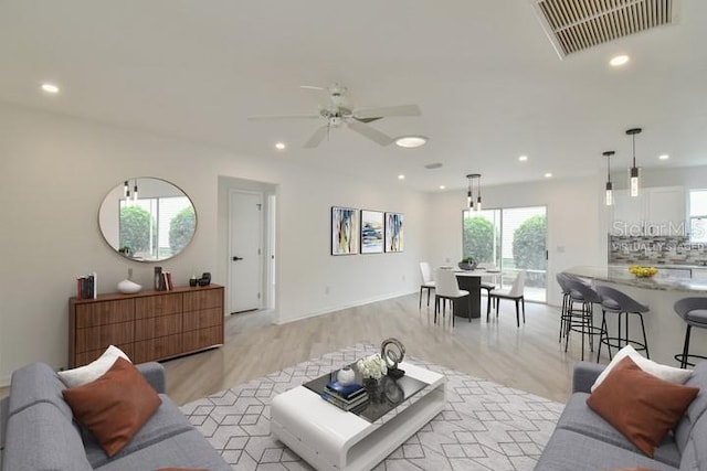 living room featuring light hardwood / wood-style floors and ceiling fan