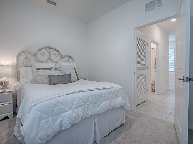 bedroom with a closet and light tile patterned flooring