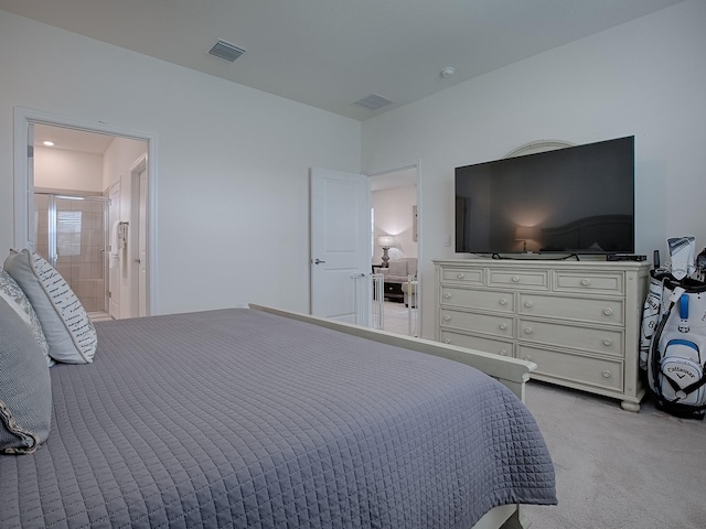 bedroom featuring ensuite bath and light carpet