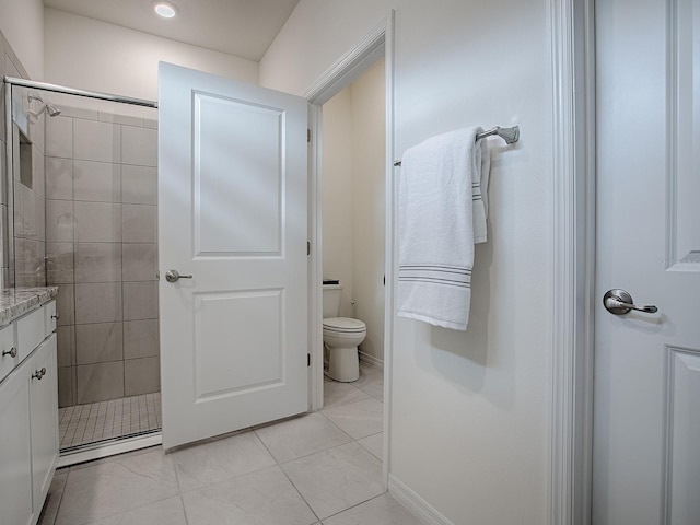 bathroom with vanity, toilet, and a tile shower