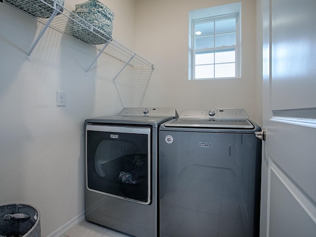 clothes washing area with light tile patterned flooring and independent washer and dryer