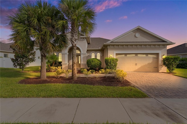 view of front of house featuring a garage and a yard