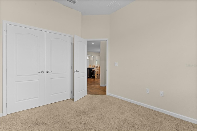 unfurnished bedroom featuring carpet flooring and a closet