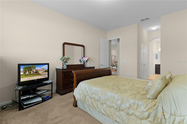 carpeted bedroom featuring ensuite bathroom