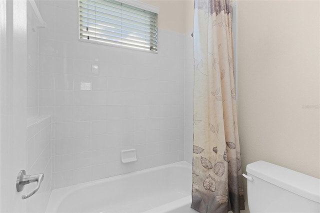 bathroom featuring shower / bath combo with shower curtain and toilet