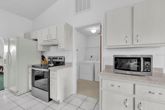 kitchen featuring appliances with stainless steel finishes, lofted ceiling, light tile patterned flooring, and washing machine and clothes dryer