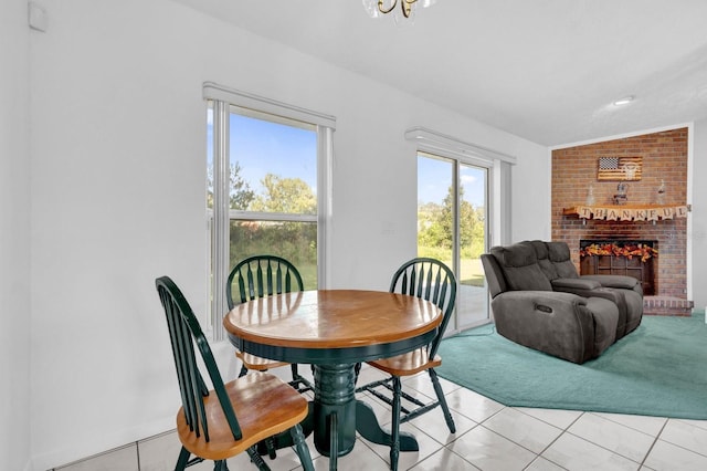 dining area featuring light tile patterned flooring, a fireplace, and vaulted ceiling