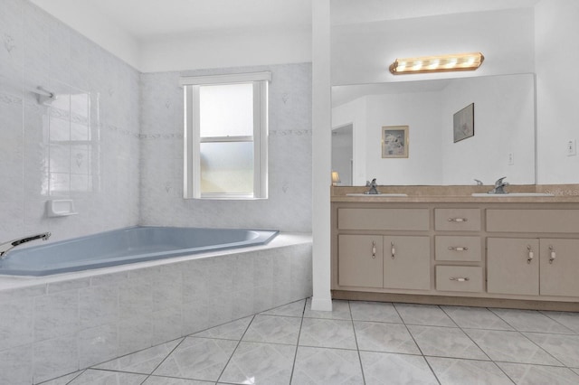 bathroom with vanity, tile patterned flooring, and tiled tub