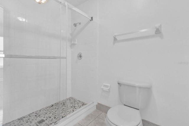 bathroom featuring toilet, tile patterned floors, and an enclosed shower