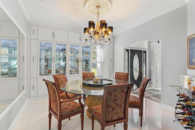 dining area featuring crown molding, light tile patterned floors, and a chandelier