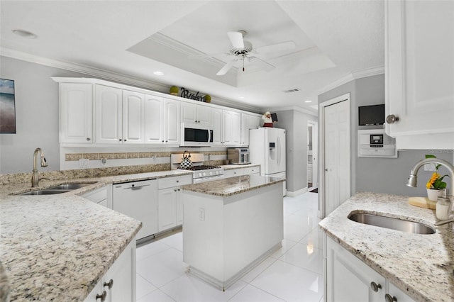 kitchen with white cabinetry, sink, a raised ceiling, and white appliances