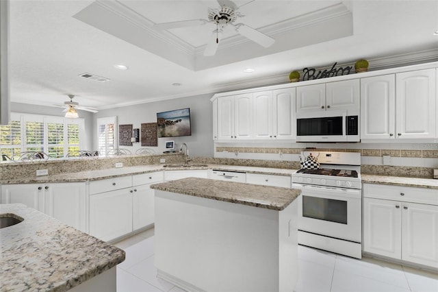 kitchen with white appliances, crown molding, kitchen peninsula, and white cabinets