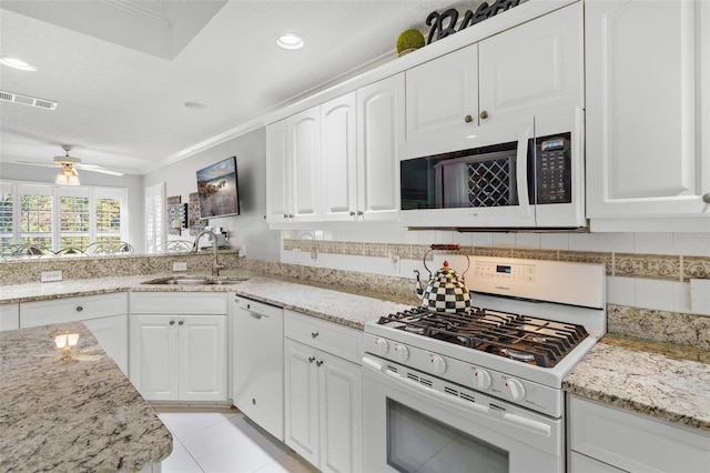 kitchen with ornamental molding, sink, light tile patterned floors, white cabinetry, and white appliances