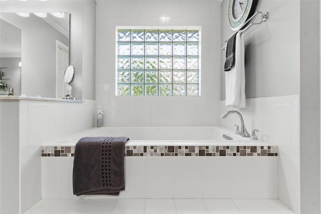 bathroom with tile patterned floors, ornamental molding, and tiled tub