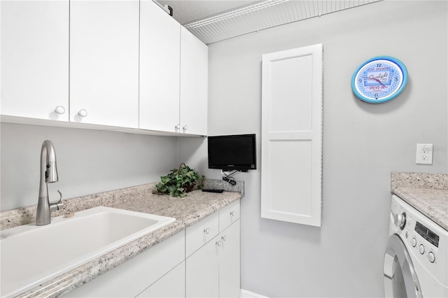 washroom with washer / clothes dryer, sink, and cabinets