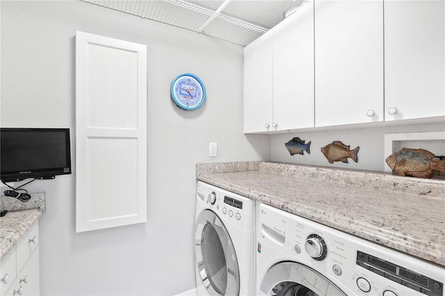 laundry room featuring washer and dryer and cabinets