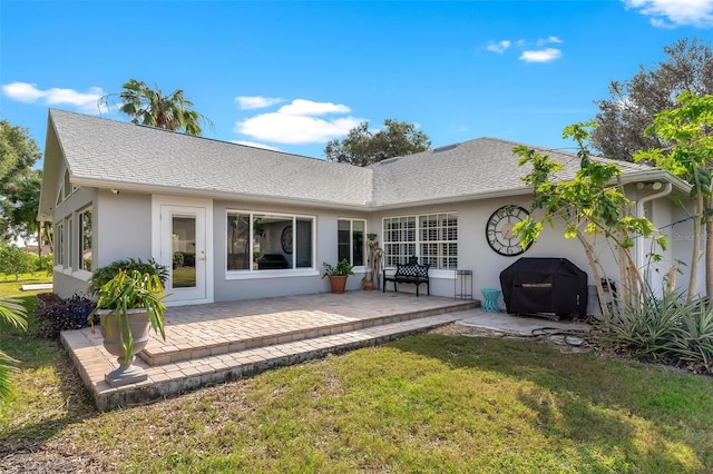 back of property featuring a patio and a lawn