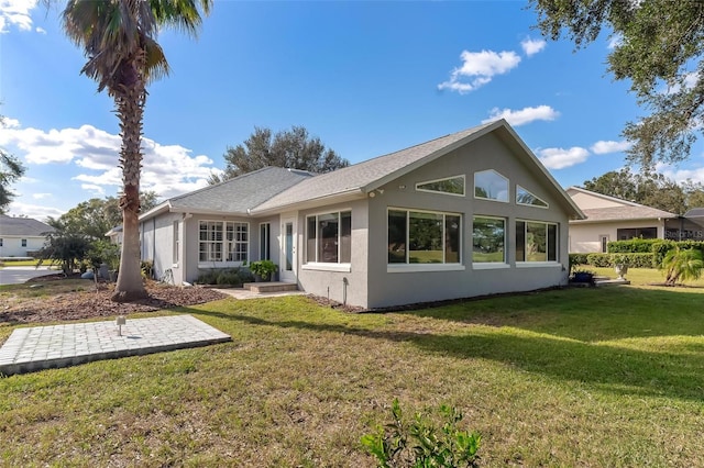 rear view of property featuring a lawn