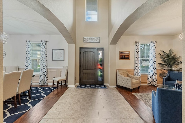 349 Morning View Dr, Winter Garden, FL 34787 - foyer featuring arched walkways, healthy amount of natural light, a towering ceiling, and wood finished floors