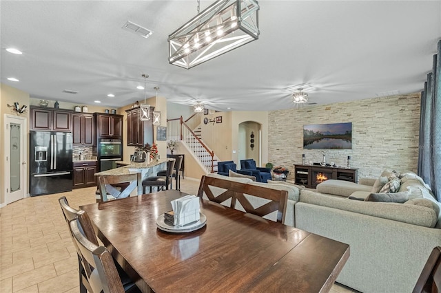 dining room featuring ceiling fan and a fireplace