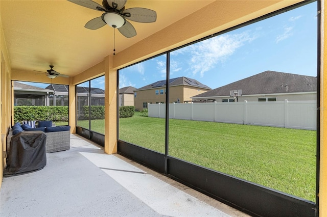 unfurnished sunroom featuring ceiling fan