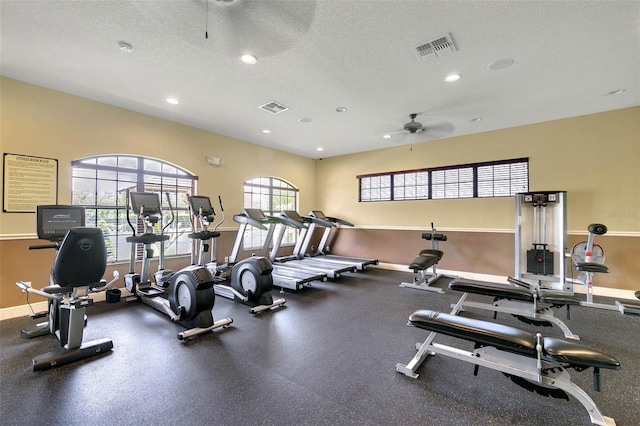 exercise room with a textured ceiling and ceiling fan