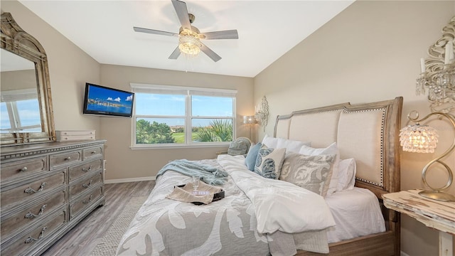 bedroom with light hardwood / wood-style flooring, lofted ceiling, and ceiling fan