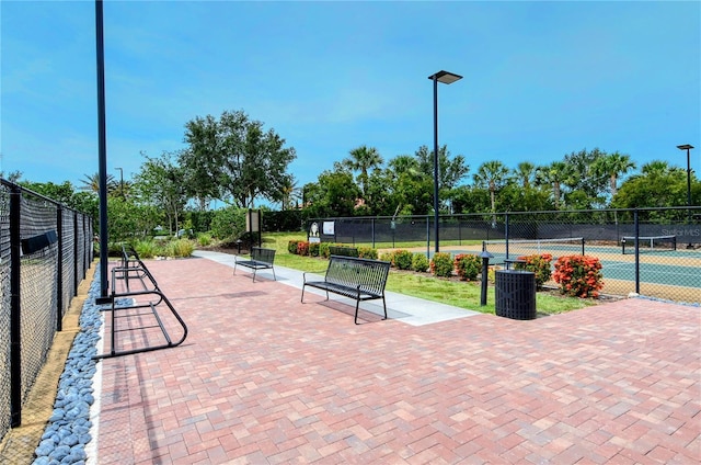 view of home's community featuring fence and a tennis court