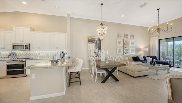 kitchen with stainless steel appliances, hanging light fixtures, and white cabinets