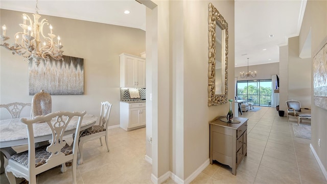 hall featuring light tile patterned flooring, a towering ceiling, and a notable chandelier