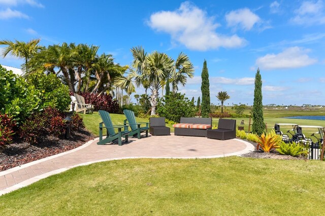 view of yard featuring a water view, outdoor lounge area, and a patio