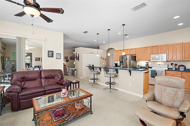 living room with ceiling fan and light colored carpet