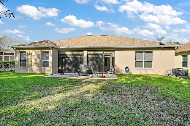 rear view of house featuring a patio, a yard, and central AC