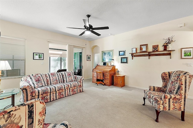 carpeted living room with a textured ceiling and ceiling fan