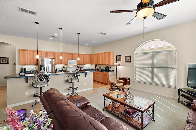 tiled living room featuring a textured ceiling and ceiling fan