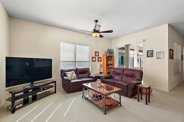 carpeted living room with ceiling fan