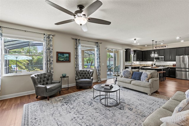 living room featuring dark hardwood / wood-style flooring, a textured ceiling, ceiling fan, and a wealth of natural light