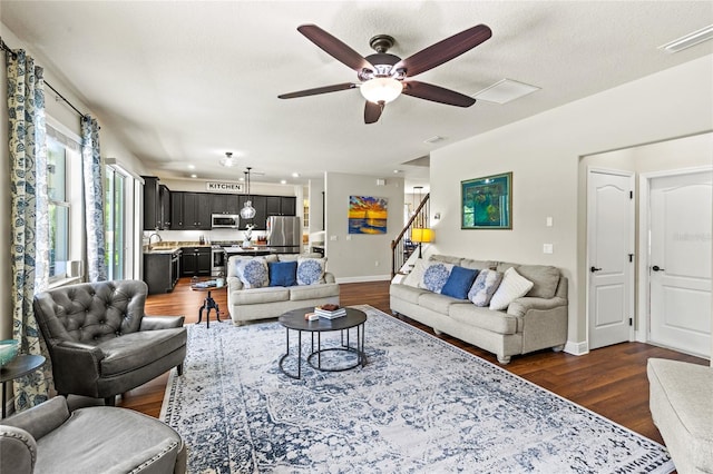 living room featuring sink, ceiling fan, a textured ceiling, and dark hardwood / wood-style floors