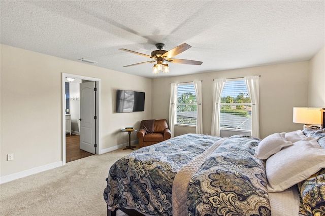 bedroom with a textured ceiling, ceiling fan, and carpet flooring