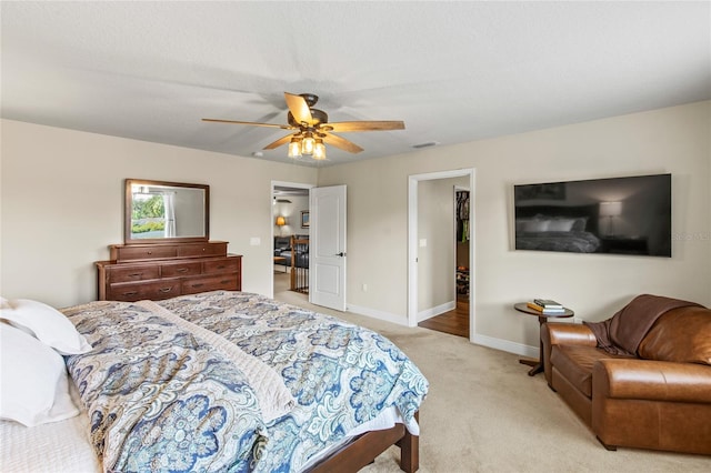 carpeted bedroom featuring ceiling fan, a spacious closet, and a closet